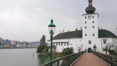 Tarihi ort Seeschloss panoraması (göl Kalesi) ve Landschloss (Kara Kale) sisli yağmurlu bir gün Traunsee Gölü genelinde ahşap köprü, Gmunden, Salzkammergut, Avusturya.