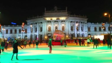 Viyana, Avusturya-18 Şubat 2019: akşam Burgtheater sürme tramvaylar ve ön planda Rathausplatz meydanında parlak aydınlatmalı buz pateni pisti, 18 Şubat Viyana 'da.
