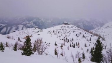 Ağır sis, Ebensee, Salzkammergut, Avusturya karlı yamaçlarda, telesiyej ve kayalık Alpleri bir görünüm ile puslu havalarda Feuerkogel dağ Plato.  