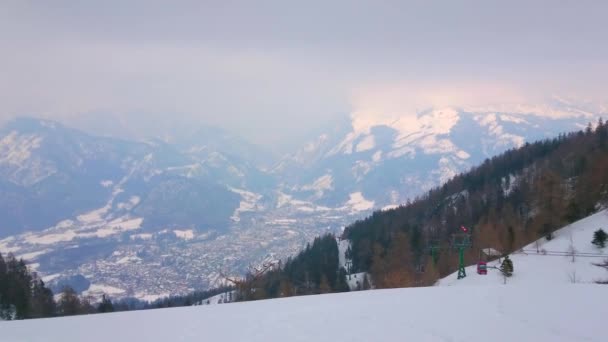 カトリン山の雪の斜面 前景のケーブルカーの速いキャビン ザルツカンマーグート オーストリアなどの悪いバートイシュル渓谷の霧の天気 — ストック動画