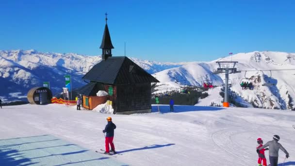 ツェル オーストリア 月28 2019 スキーは 2月28日にツェルで 古い木造のエリザベート礼拝堂に沿ってゲレンデ Schmitten 山にスキーリフトからスケートをしています — ストック動画