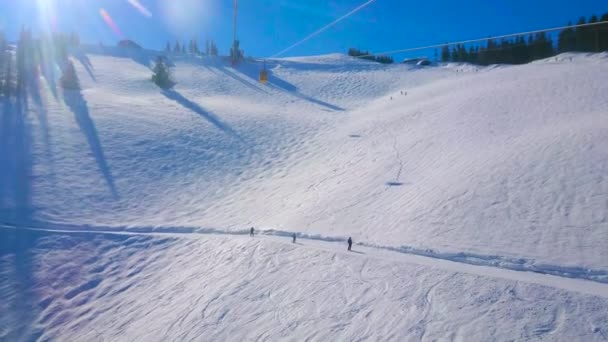 索道俯瞰Zwolferhorn山的缓雪坡 上面覆盖着运动员的滑雪道和雪鞋小径 参观奥地利萨尔茨卡默古特的冬季度假胜地 — 图库视频影像