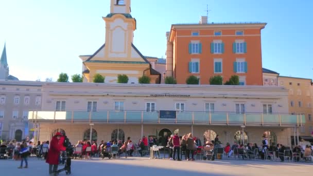 奥地利萨尔茨堡 2019年2月27日 2月27日 在萨尔茨堡 在拥挤的莫扎特广场 莫扎普拉茨 的户外餐厅 欣赏圣迈克尔教堂 Michaelskirche 的钟楼景色 — 图库视频影像
