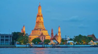 Bangkok, Tayland - 22 Nisan 2019: Parlak akşam aydınlatma görkemli ortaçağ Wat Arun Tapınağı ile Chao Phraya nehri Thonburi kıyısında görünümü, Bangkok Nisan'da 22 