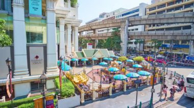 Bangkok, Tayland - 24 Nisan 2019: 24 Nisan'da Bangkok'ta, Erawan Tapınağı ile yoğun Ratchaprasong kavşağı, araba sürme, Skytrain köprüsü, modern alışveriş merkezleri ve iş merkezleri izle 