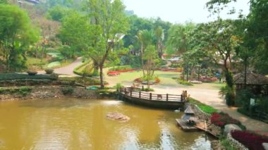 Yemyeşil ağaçlar ve çiçek yatakları ile çevrili küçük göl ile mükemmel peyzajlı Mae Fah Luang (Doi Tung) botanik bahçesi, Chiang Rai, Tayland
