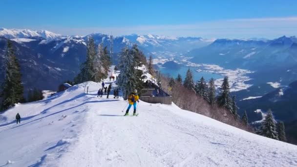 スキーランを持つ雪のズヴォルファーホルン山頂 斜面のスプルース アルパイン山脈 ザルツカマーグート オーストリアの周囲の背景に見られるアズールヴォルフガング湖の谷 — ストック動画