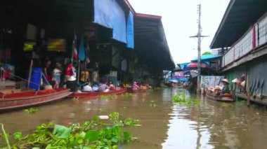 DAMNOEN SADUAK, THAILAND - 13 Mayıs 2019: Damnoen Saduak 'taki egzotik eğlence ve ilginç alışveriş alanı olarak bilinen yüzen pazarın klong (kanal) boyunca tekne turunun tadını çıkarın