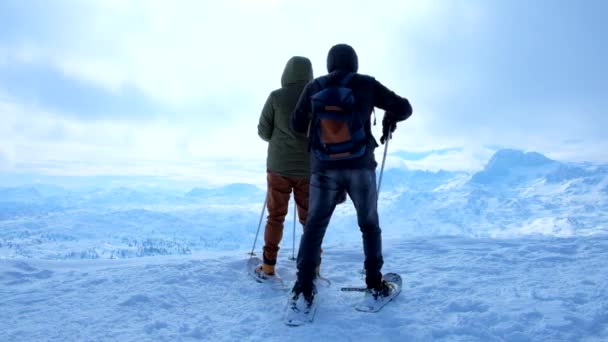 雪の浅いカップルは クリッペンシュタイン山の端に滞在し 雪のダッハシュタイン塊の風景を観察し セルフを作ります Obertraun ザルツカンマーグート オーストリア — ストック動画
