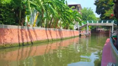 Turist feribot dar Klong Saensaeb (kanal), eski şehir, Bangkok, Tayland eski şehir eski evler ve yemyeşil bahçeleri ile kaplı boyunca yüzer