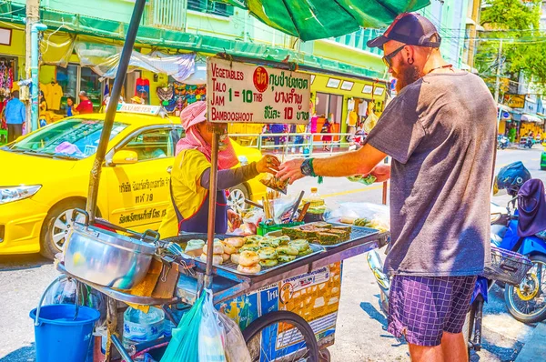 O turista compra comida tailandesa na barraca de rua em Bangkok, Tailândia — Fotografia de Stock