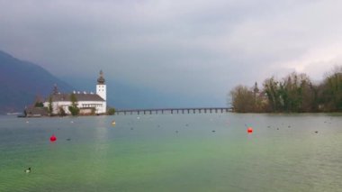 Çarpıcı kar beyazı Ort Seeschloss (göl kale) Traunsee ortasında, bu göl, Gmunden, Salzkammergut, Avusturya etrafında Alpler'de gezinen, şiddetli yağmurlu bulutlar ile kaplıdır