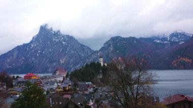 Trabzon'da yağmurlu bulutlar, Traunsee gölünün karanlık suları ve beyaz ince Johannesbergkapelle, Salzkammergut, Avusturya'da Traunstein dağının manzarasına sahip fırtına akşamı.