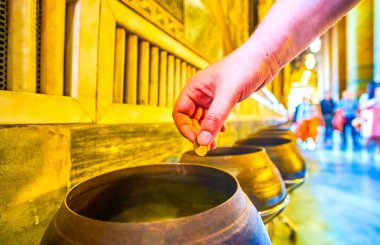 Wat Pho tapınağında bronz kasede sikke bırakarak, Bangkok, Thailan