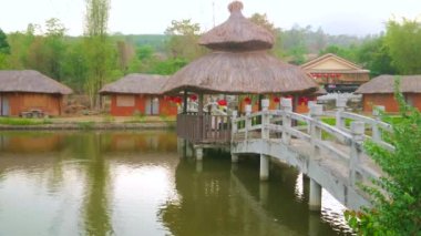 Ahşap köprü ile doğal gölet boyunca yürümek ve Santichon Çin Yunnan kültür köyünün geleneksel evler izlemek, Pai, Tayland yanında dağlarda bulunan
