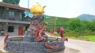 Naga yılan ve büyük yaldız çaydanlık ile çay mağazasında doğal çeşme, çay toplayıcı fincan su dökme, Mae Salong Çin Yunnan çay köyü, Chiang Rai, Tayland