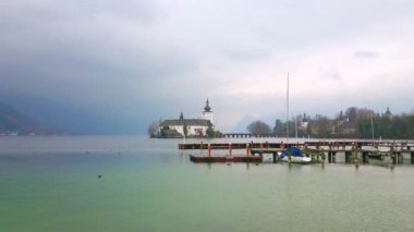 Gmunden'de yağmurlu hava, Traunsee gölü ve Seeschloss Ort kalesinin üzerinde sıkışmış ağır bulutlar, tersane arkasında görülüyor, Salzkammergut, Avusturya
