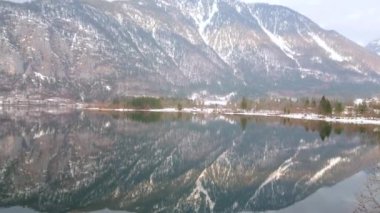 Ayna yüzeyine yansıyan ikonik Alpine Hallstattersee gölü ve karlı Dachstein dağlarının panoraması, Hallstatt, Salzkammergut, Avusturya.