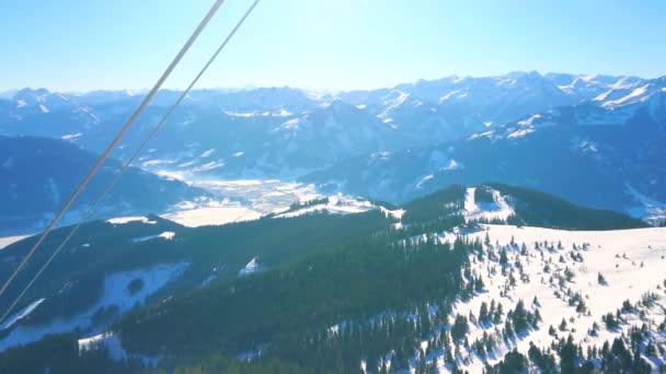 浅蓝色的薄雾覆盖了尖锐的阿尔卑斯山峰和雪坡 从施密滕霍赫山峰通过索道电线 泽尔阿姆西 奥地利 — 图库视频影像
