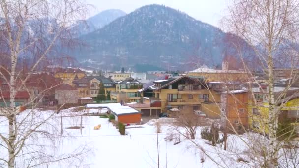 シリウスコグル山の丘は 古い生きた家や白樺の木とアルプスを背景に オーストリアのザルツカマーグトと悪いイシュルの雪の谷を見渡せます — ストック動画