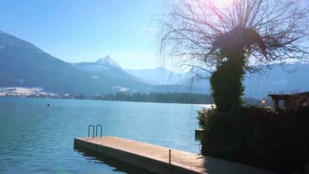 阳光明媚的冬日是完美的放松在沃尔夫冈湖的堤岸 享受田园诗般的阿尔卑斯山自然 圣沃尔夫冈 萨尔茨卡默古特 奥地利 — 图库视频影像