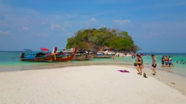 Ao Nang, Tayland - 26 Nisan 2019: 26 Nisan 2019 tarihinde Ao Nang'da, demirli uzun kuyruklu tekneler ve yeşilliklerle kaplı küçük Koh Tup Adası manzaralı Koh Mor Adası'nın beyaz kumlu sığ plajı 