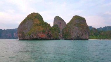 Railay Yarımadası'nda büyük kayalar üzerinde günbatımı gökyüzü, Andaman deniz suları, Ao Nang, Krabi, Tayland tarafından yıkanmış