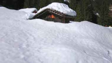 Derin kar Dachstein Alpleri'nde yayla vadisi kapsar, erimiş kar akıntıları eski ahşap evin çatısından aşağı düşer, uzun kar yığınları ile görülen, Gosau, Avusturya