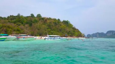 Ao Nang, Tayland - 27 Nisan 2019: Demirli sürat tekneleri, çok sayıda turist, yemyeşil bambu yeşillikleri ve Andaman denizinin zümrüt suları ile Ko Mai Phai (Bambu Adası) sahili, 27 Nisan'da Ao Nang'da