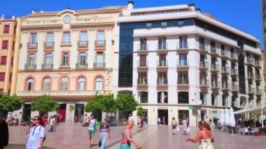 Malaga, İspanya - 26 Eylül 2019: Anayasa Meydanı Panoraması 'nda klasik yapılarda dükkanlar ve kafeler ve yüksek palmiye ağaçları önünde oyulmuş taş Ceneviz Çeşmesi, 26 Eylül' de Malaga 'da