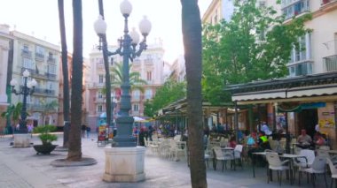 Cadiz, İspanya - 19 Eylül 2019: Plaza de San Juan de Dios meydanında arka planda açık kafe, palmiye ağaçları ve Pazos Miranda House bulunan klasik sokak lambası, 19 Eylül 'de Cadiz' de
