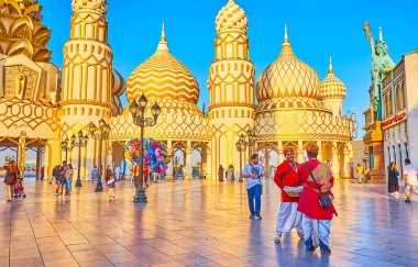 DUBAI, BAE - 5 Mart 2020 'de Dubai' deki Global Village Dubai 'nin kapısında ellerinde sepetler dolusu abur cubur bulunan geleneksel Doğu giysili sokak satıcıları