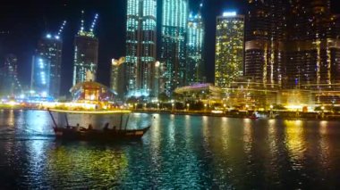 DUBAI, BAE - 3 Mart 2020: 3 Mart 'ta Dubai Çeşmesi' ni izlemek için mükemmel bir yer arayan küçük turist botu Burj Halife Gölü 'nde yüzüyor.