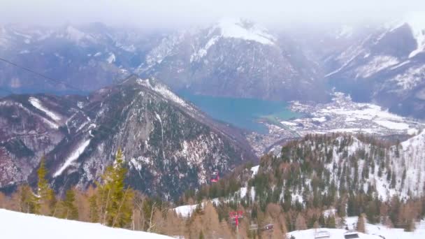 Ebensee Austria 2019年2月24日 フェウエルコゲル山は霧のトラウンゼー渓谷を見下ろす明るい青のトラウン湖と赤いリフトで 2月24日にエベンゼーで山頂に乗っています — ストック動画