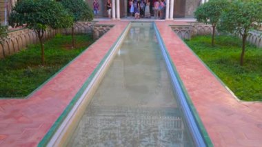 SEVILLE, SPAIN - 1 Ekim 2019: Tarihi Patio de las Doncellas Panorama (Bakirelerin Avlusu), 1 Ekim 'de Seville' de bulunan sebka, Alcazar Sarayı 'nda süslü püslü dantel benzeri duvarların arasında bir gölet ile