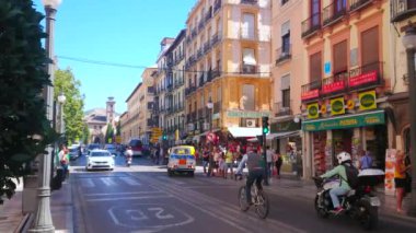 Grand ANADA, SPAIN - 27 Eylül 2019 'da Granada' daki Plaza Nueva Meydanı 'nda sürüş arabaları, eski binalar, kalabalık insanlar ve arka planda San Gil ve Santa Ana Kilisesi vardı.