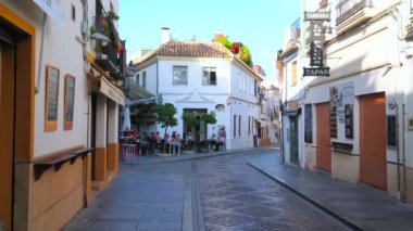 CORDOBA, SPAIN - 30 Eylül 2019: 30 Eylül 'de Cordoba' da, eski dar sokaktaki ortaçağ kasaba evleriyle dolu küçük bir açık hava kafe