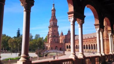 İspanya, Seville 'deki Plaza de Espana kompleksinin tuğla galeri kemerlerinden kuleye bakan manzara.