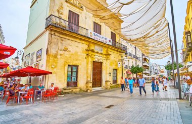 SANLUCAR, SPAIN - 22 Eylül 2019: Calle San Juan caddesinde bulunan ve 22 Eylül 'de Sanlucar' da sokak kafeleriyle çevrili belediye kütüphanesinin tarihi binası