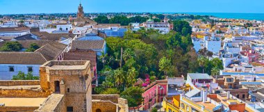 Castillo de Santiago şatosu eski kiremit şehir çatılarına, büyük şarap imalathaneleri binalarına, kaliteli şeri, yaşam alanları ve yüksek kilise kuleleri, Sanlucar, Endülüs, İspanya