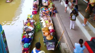 DAMNOEN SADUAK, THAILAND - 13 Mayıs 2019: Damnoen Saduak yüzer pazarı örnek yiyecek ve hediyelik eşya satan teknelerle 13 Mayıs 'ta Damnoen Saduak' ta yerel yemekler, atıştırmalıklar, meyveler, koni şapkalar sunuyor.