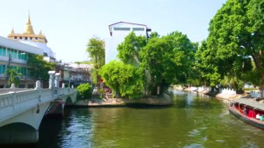 BANGKOK, THAILAND - 24 Nisan 2019: Uzun feribot, 24 Nisan 'da Bangkok' taki Golden Mount Tapınağı 'ndan geçen Maha Nak Khlong' un (kanal) dar alanında karmaşık manevralar yapar.