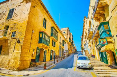 VALLETTA, MALTA - 17 Haziran 2018: Cumhuriyet Caddesi 'ndeki uzun tırmanış, 17 Haziran' da Valletta, Malta 'da eski taş yapılar, turizm dükkanları, kafeler ve aile restoranları ile kaplandı.