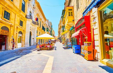 Valletta, Malta-19 Haziran 2018: tüccarlar sokak büyük miktarda turist mağazaları, ilginç Hediyelik eşya mağazaları, açık hava kafeler ve tarihi binalar, 19 Haziran Valletta içinde Bastlara