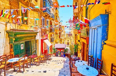 Valletta, Malta-19 Haziran 2018: St Lucia Sokak iniş boyunca rahat açık bar streç tablolar, renkli bayrak çelenk ile süslenmiş, Haziran 'da 19 Valletta