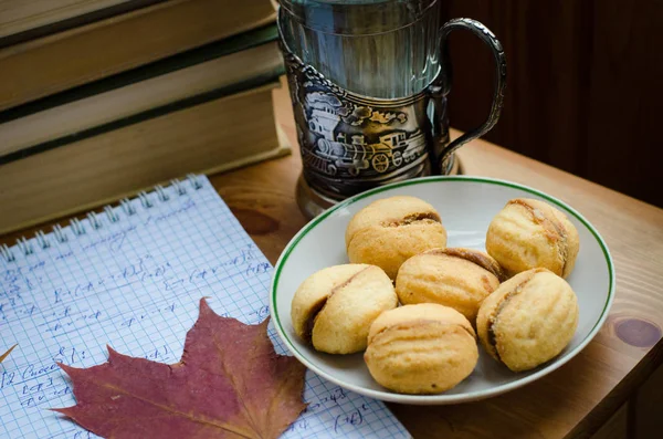 Rus ceviz ile haşlanmış yoğunlaştırılmış süt bir daire, eski kitaplar, matematik notları (mantık notlar), kurutulmuş yaprakları ve çay cam holde (Podstakannik) ahşap bir masa tanımlama bilgileri (