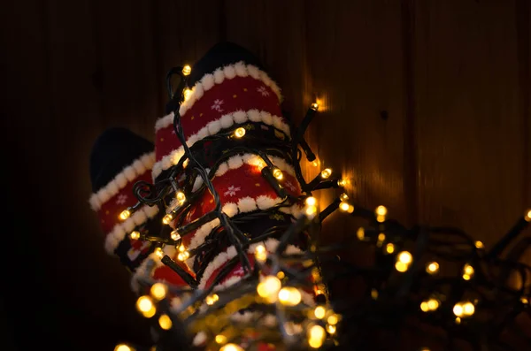 Sıcak beyaz ışıklar ve ayak Noel çorap yol açtı. Geç akşam evde kız rahatlatıcı. Kış tatil Noel ve yeni yıl kavramı.