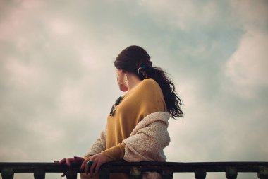 Fotoğraf güzel bir kadının dramatik gökyüzüne bakarak