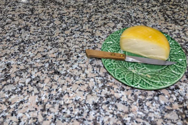 一张美味的葡萄牙奶酪的照片放在盘子里拿着一把刀 — 图库照片