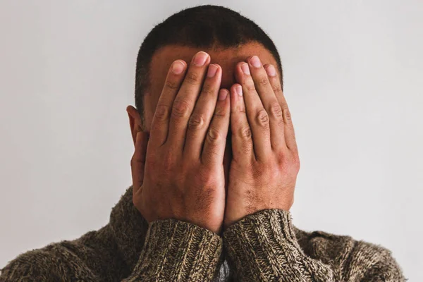 Portrait of a man covering face with hands